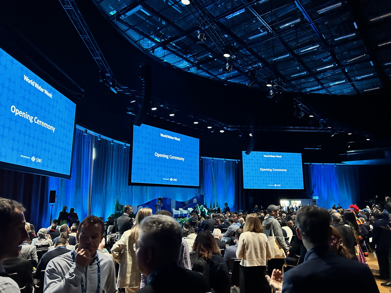 A crowd of people looking at blue screens
