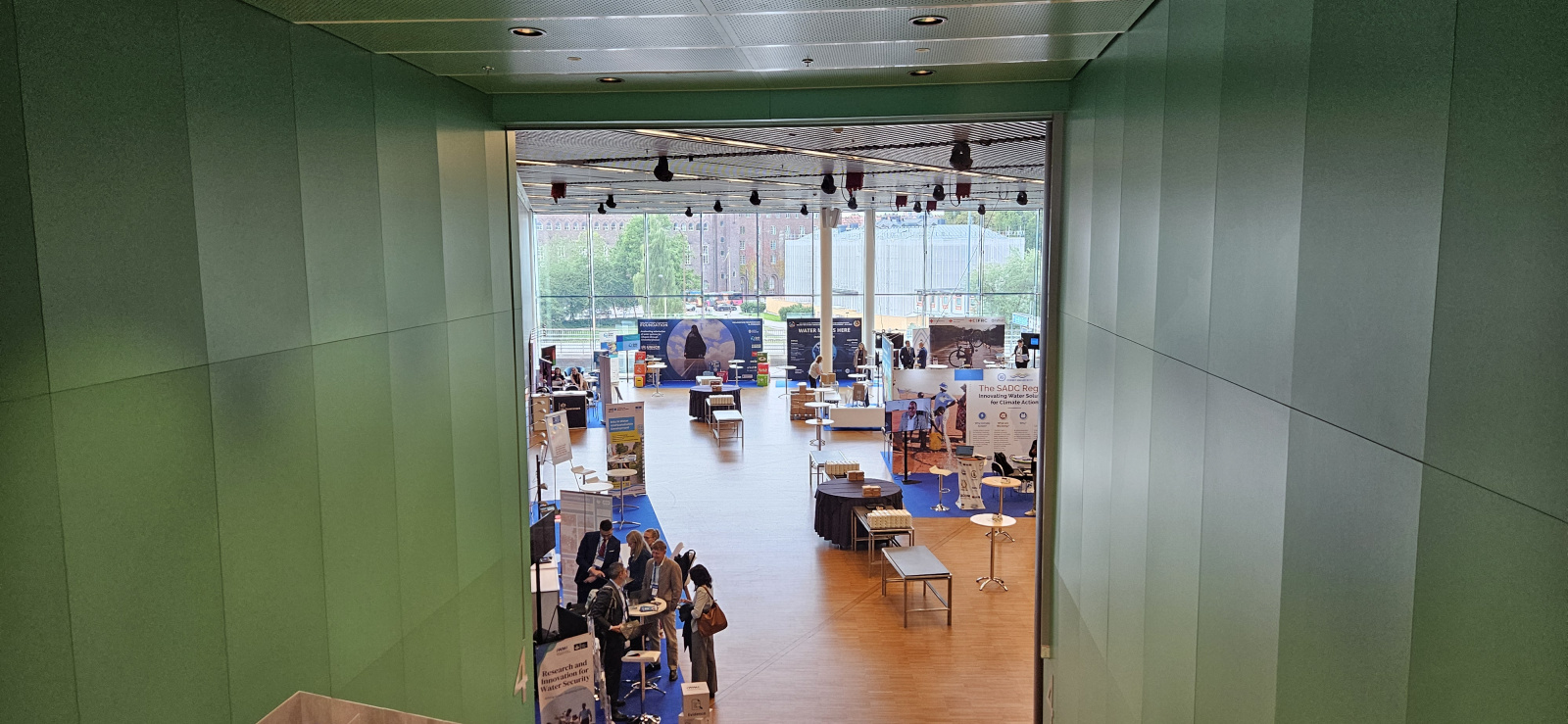 the entrance of a poster session with people walking around the room