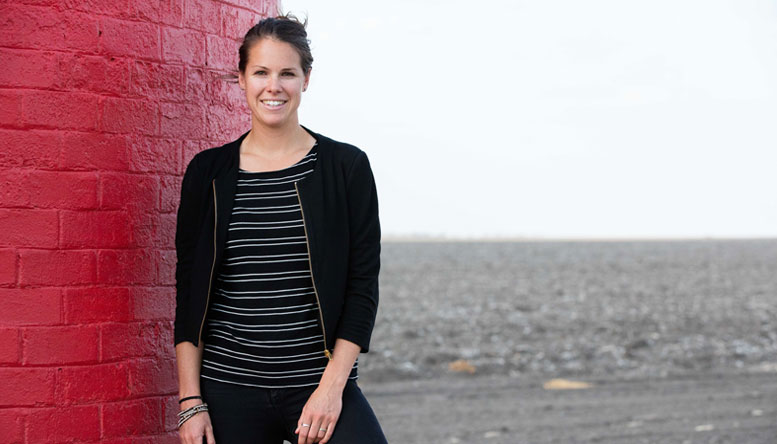 Sarah Nolet standing next to a red wall