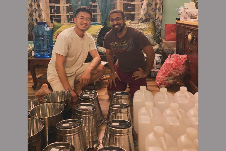 Jon Besssette on the left and Gokul Sampath on the right assemble many steel water buckets in a home in India