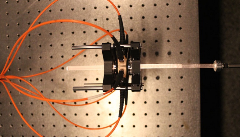 Heptapod with seven orange optical fibers fixed around glass rod.