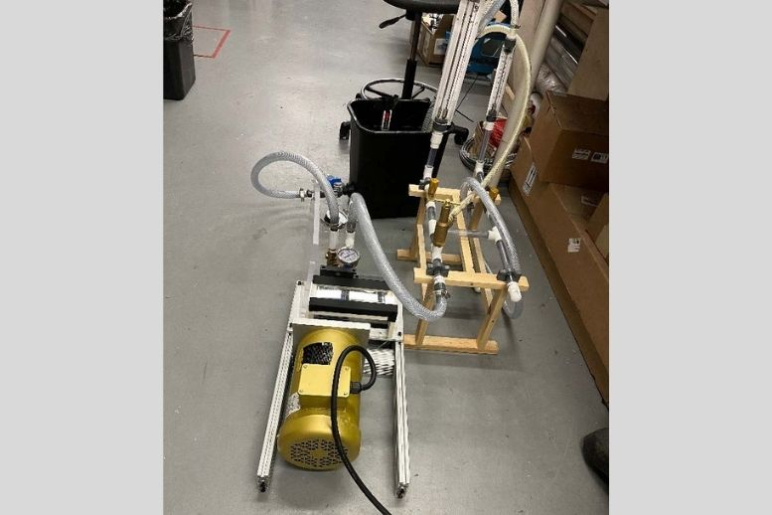 Experimental pump setup with a gold cylinder pump device with tubes coming out of it