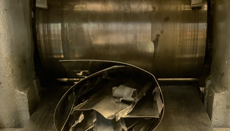 A piece of metal going into a roller