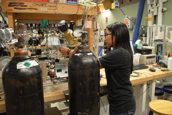 A female researcher works in a crowded lab setting