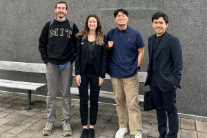 Picture of the 4 MIT students in front of a gray wall