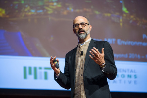 An individual giving a presentation in front of a projector screen