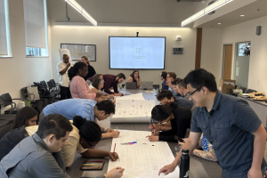 Large group of students working around a conference room table