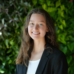 A portrait of an individual against a green background.