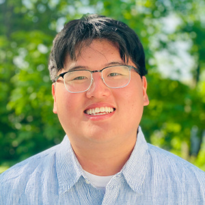 A portrait of an individual against a green background.
